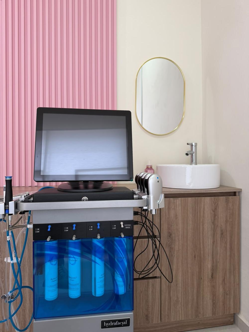 Equipo HydraFacial, espejo ovalado de latón y lavabo circular